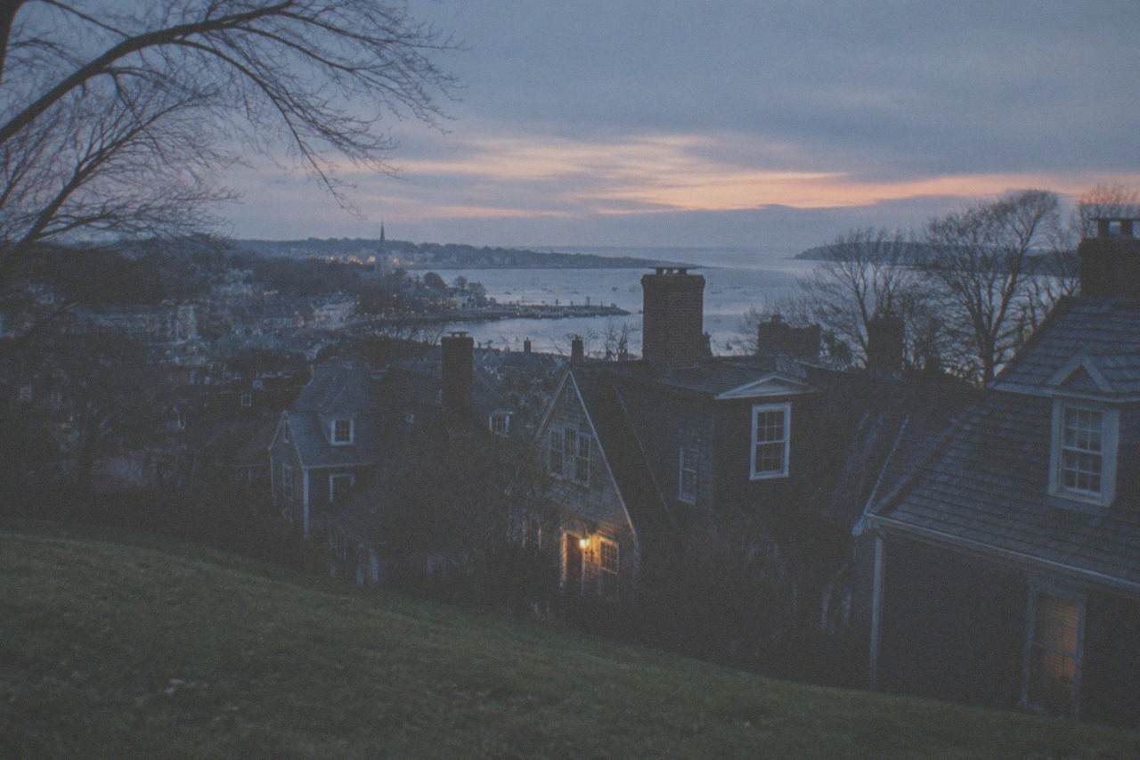 Grass-covered hillside neighborhood rooftops in Salem Massachusetts at dusk