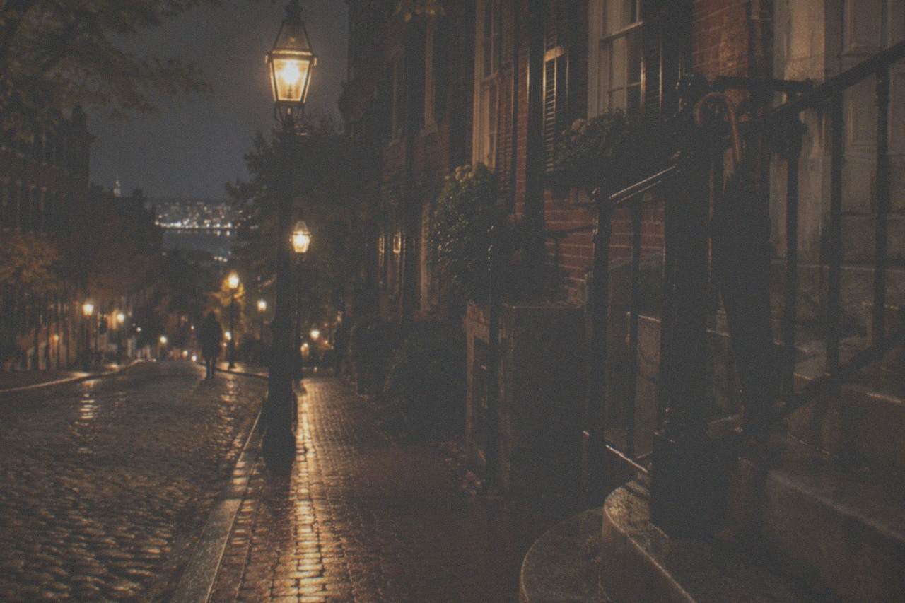 Gas lamps glowing along a quiet Beacon Hill street at night