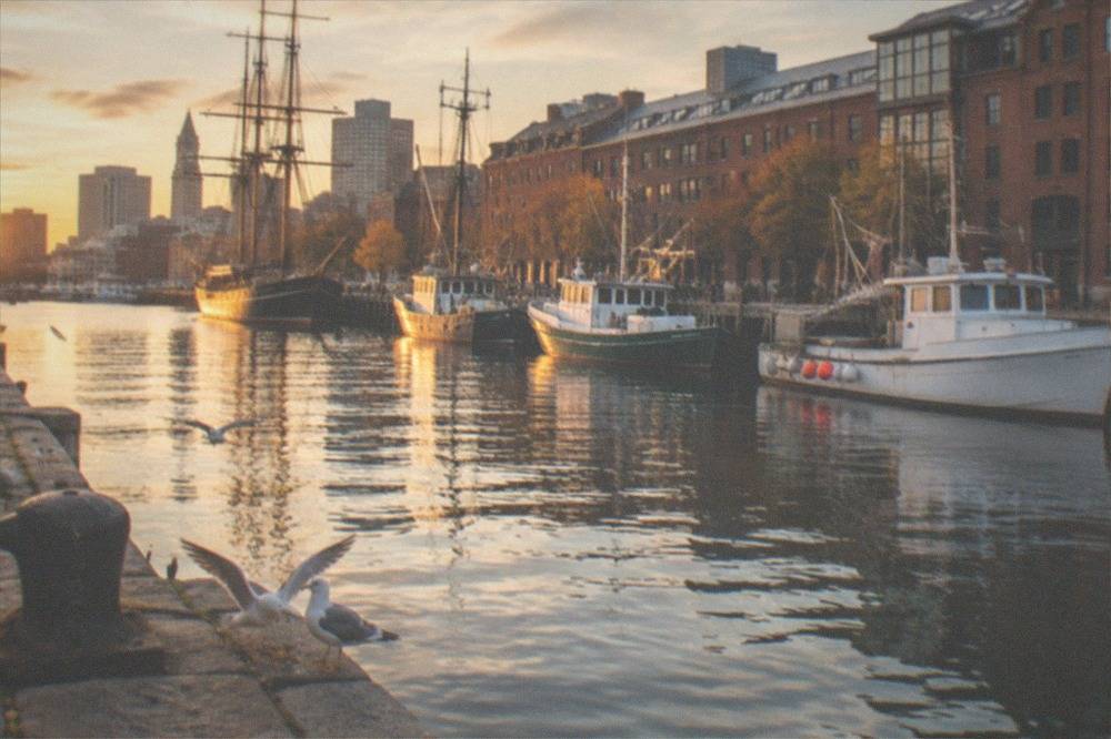 Harbor waterfront with moored boats and historic buildings in an autumn New England seaport town