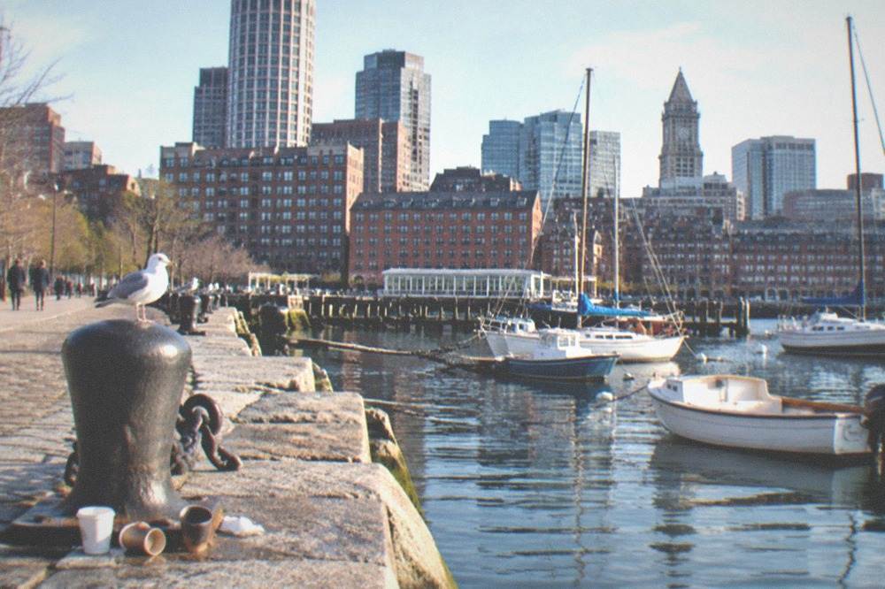 Historic stone wharf on Boston harbor waterfront with moored boats