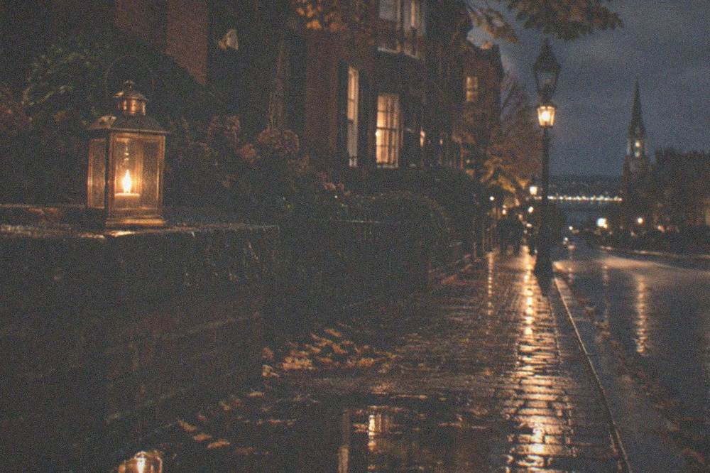 A lantern resting on a brick wall beside a darkened historic street